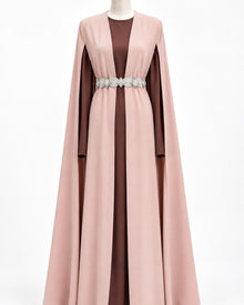 Cape longue rose clair Elegance Zaina Maxi portee sur une robe bordeaux vieux rose avec une ceinture argentee en accessoire.