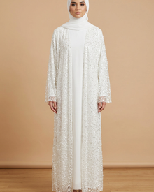 Ensemble blanc robe longue et kimono perlé porté par une mannequin sur fond beige