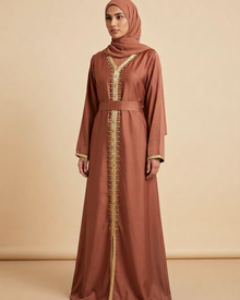 Robe longue cuivrée à strass dorés et ceinture portée par une mannequin sur fond beige