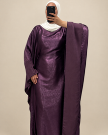 Robe longue prune à l’aspect satiné sur fond beige