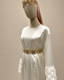 Mannequin avec ceinture aux pierres bleues sur fond beige
