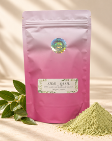 Sachet rose refermable de poudre de SIDR, présenté avec un tas de poudre verte et des feuilles de jujubier sur fond beige.