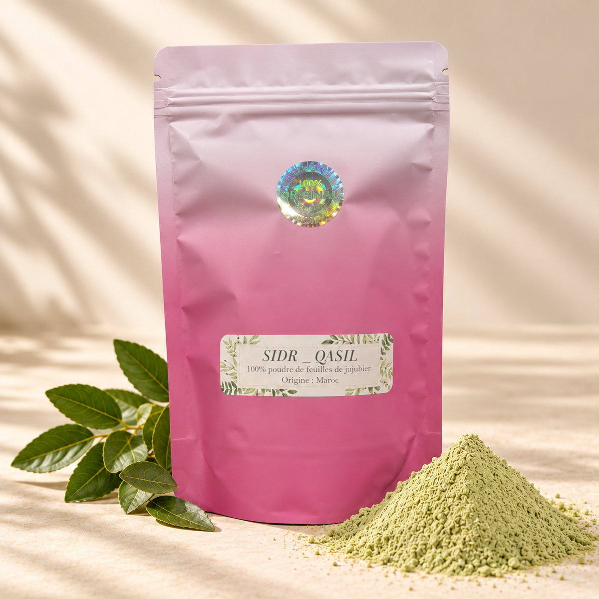 Sachet rose refermable de poudre de SIDR, présenté avec un tas de poudre verte et des feuilles de jujubier sur fond beige.