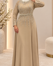Robe de soirée beige longue ornée de perles et strass sur le buste